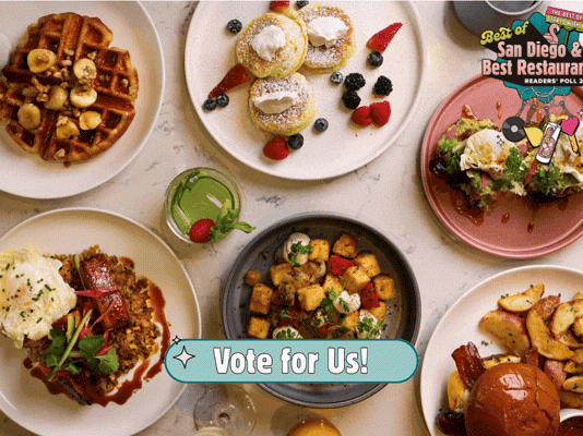 A spread of varied brunch foods: waffles, pastries, bowls, tacos, fried items, sauces, and a &ldquo;Vote for Us!&rdquo; badge in the center.